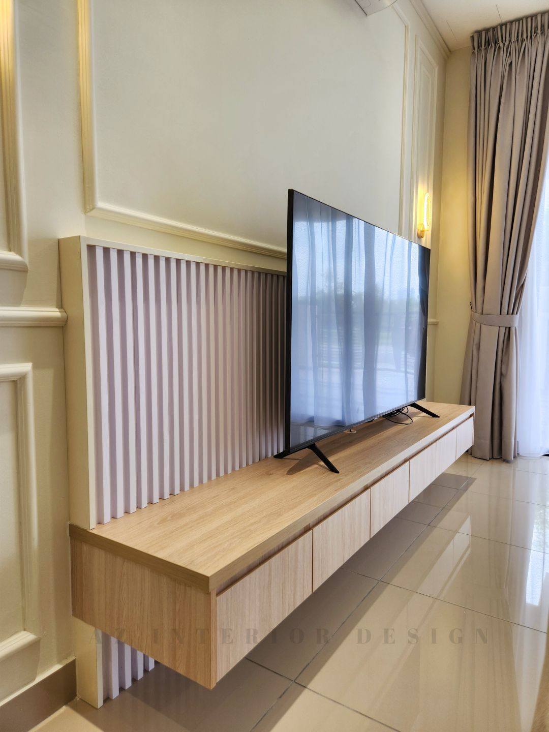 Wooden floating TV console against classic European wall paneling with soft beige tones and elegant drapery by AZ Interior Design
